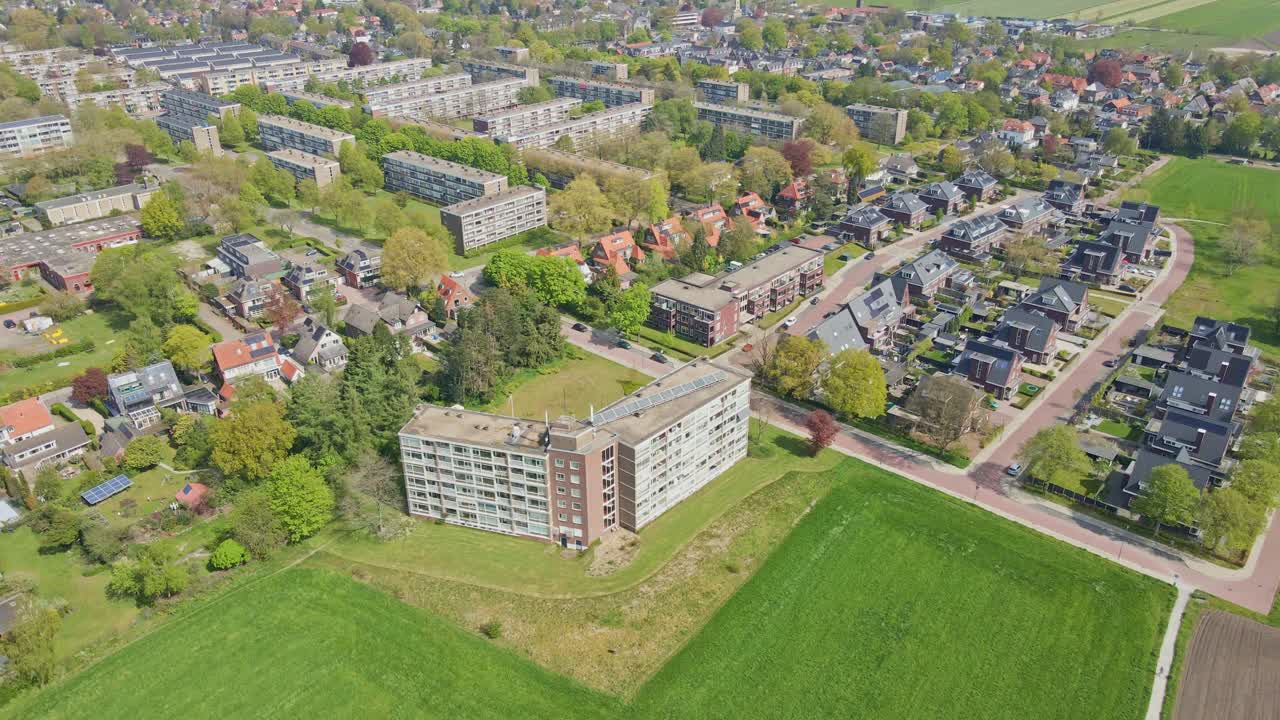 Jib up of apartment building next to suburban neighborhood in a small town