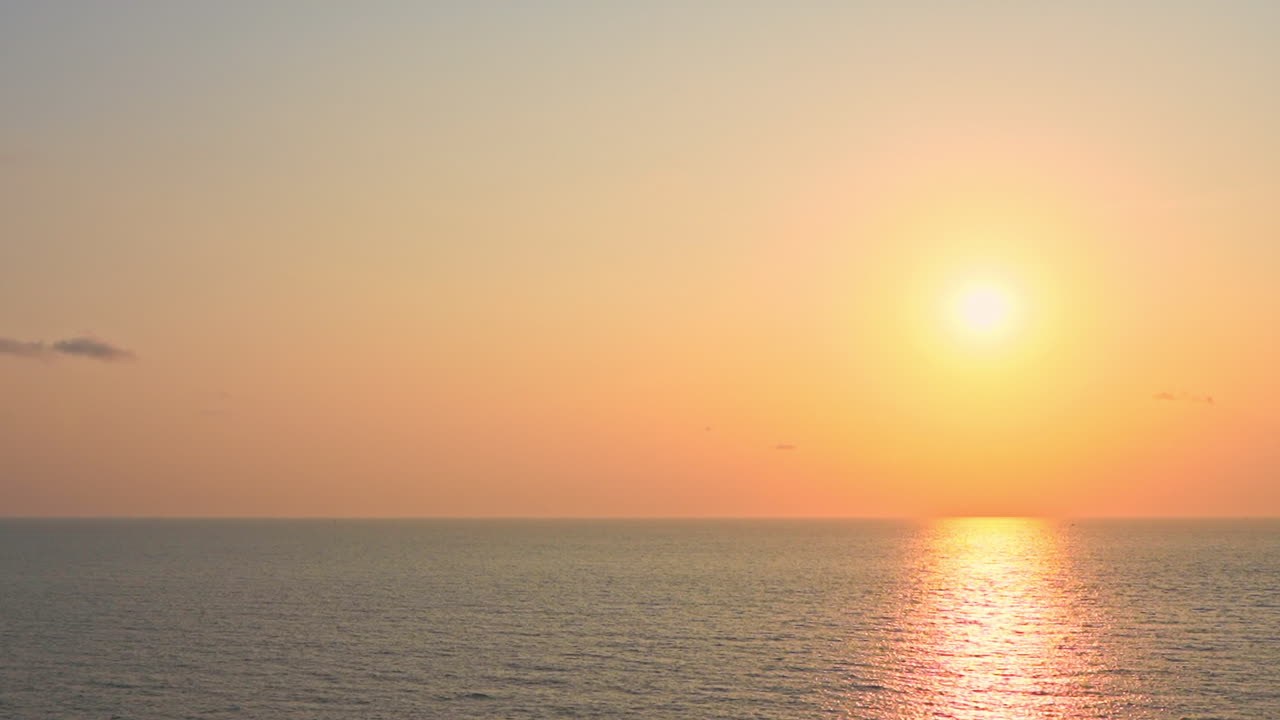 인도네시아 발리의 수면에 햇빛이 반사되어 붉은 색과 분홍색의 다채로운 해변 일몰에 끝없는 바다 경치