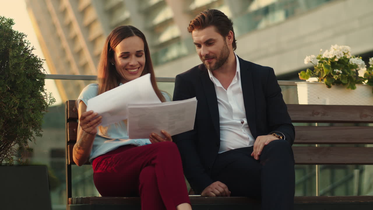 hombre de negocios positivo y mujer de negocios buscando buenos resultados de trabajo en los documentos