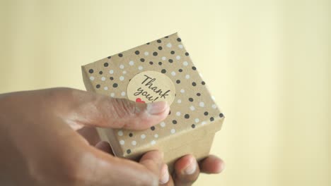 person holding a thank you gift box