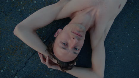 Young-Man-Looking-Into-Camera,-Shirtless,-Lying-Down,-Close-Up-Portrait,-Slow-Motion