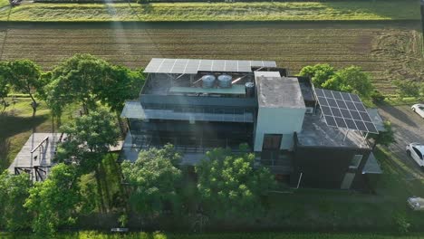 aerial view of old apartment installed with solar panels on roof in rural landscape