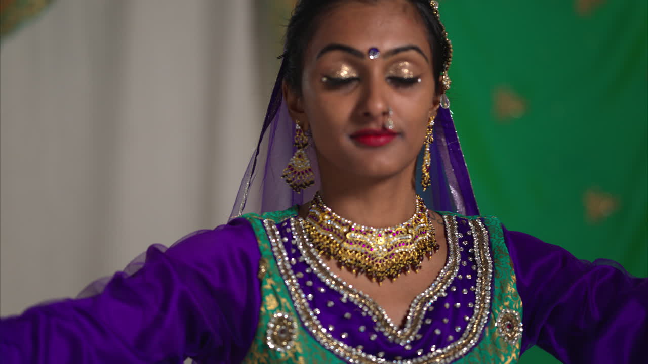 cabeza y hombros toma de estudio de una mujer sonriente bailarina de kathak realizando un baile vestida con el vestido tradicional indio 3