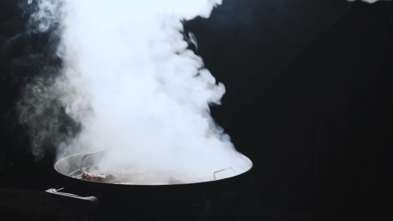 De grill openen en de rook onder de deksel vandaan laten ontsnappen