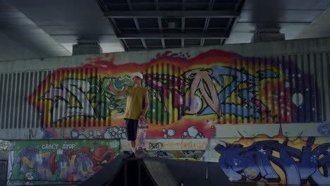 teenager making selfie photo on mobile phone at graffiti wall background.