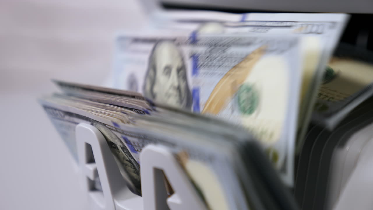 Money counting machine. Banknote counter are counting hundred dollar bills. Close-up