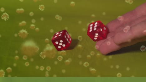 Animation-of-covid-19-cells-floating-over-two-dice-on-green-background