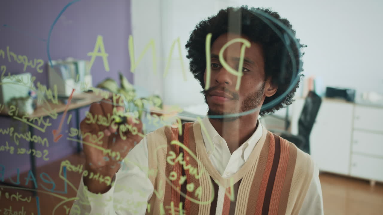 Creative Businessman Drawing Scheme on Transparent Wall at Office