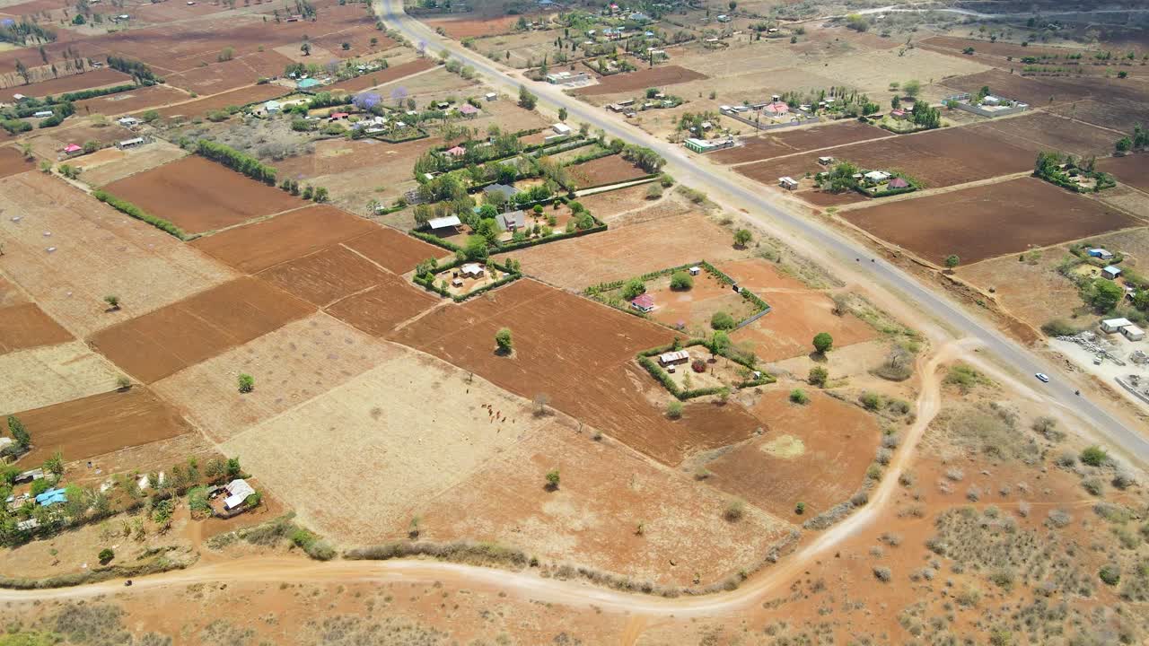 pluma abajo de un paisaje rural con casas distantes y granjas en el áfrica rural