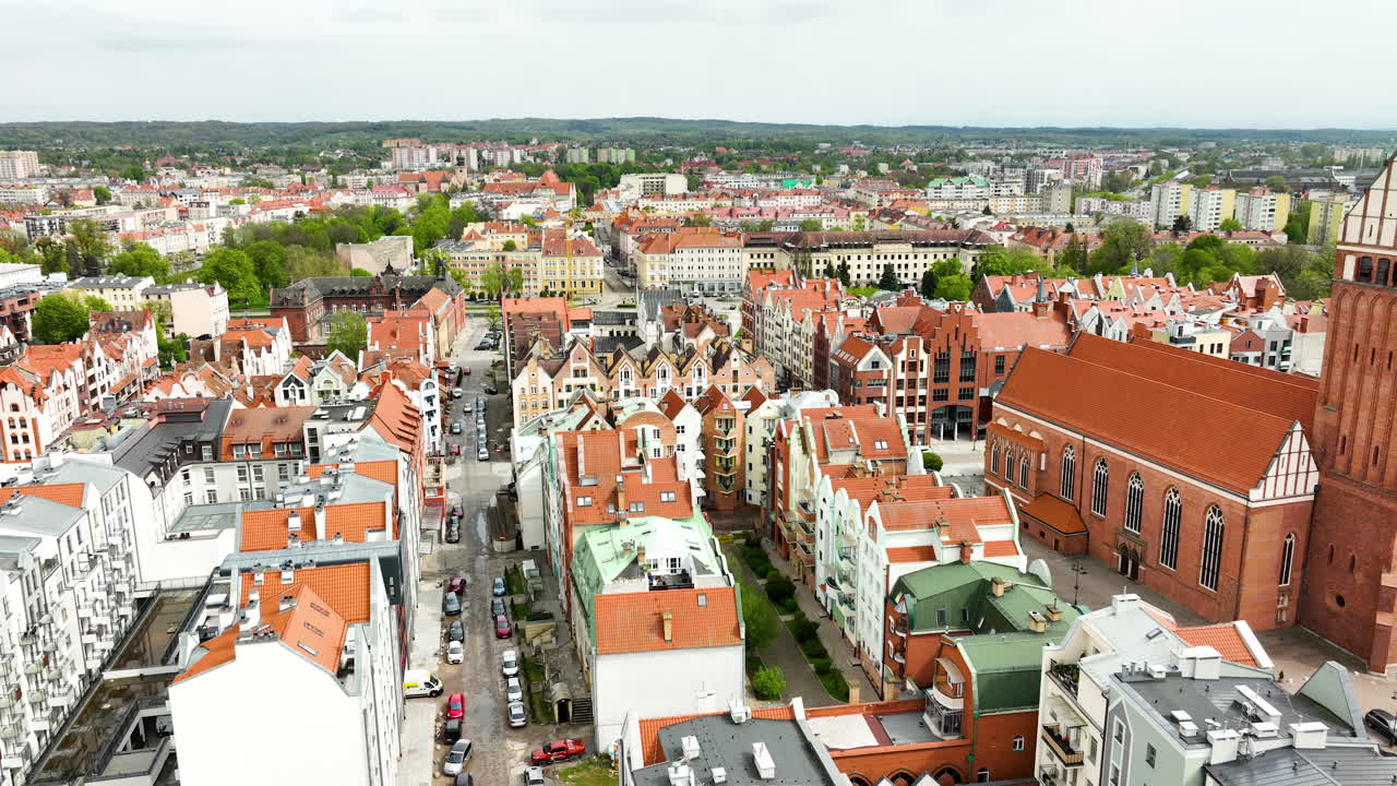vista aérea del centro de la ciudad de elbląg con una mezcla de edificios modernos e históricos, una iglesia prominente y una calle bulliciosa
