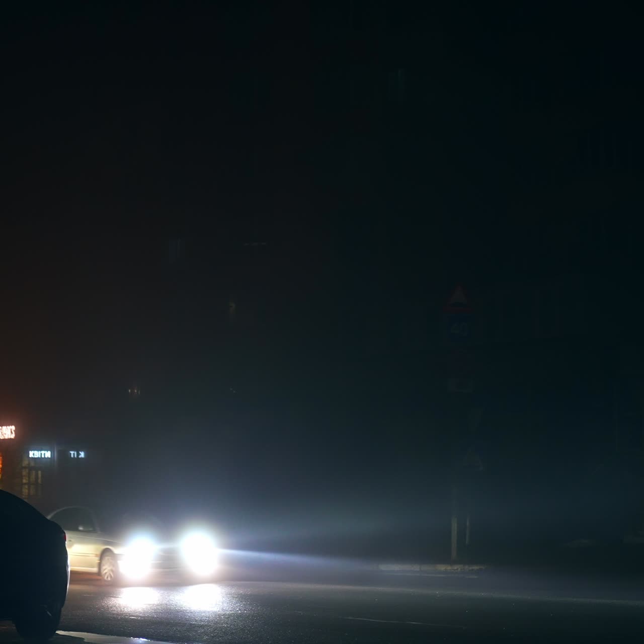 Dark windows in the houses over the car road in the Ukrainian city. Time of blackout at night time. Result of russian aggression and attacks on energy system of Ukraine