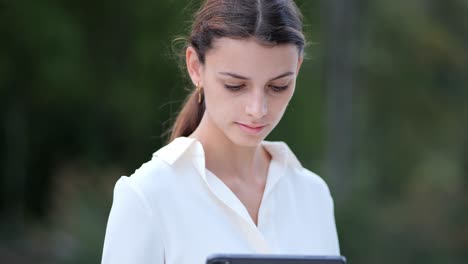 Close-up-shot-of-a-businesswomans-face-while-typing-something-on-her-tablet