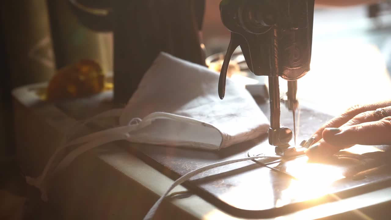 Hands Of A Woman Sewing Homemade Reusable Cloth Face Mask In White Fabric On A Manual Sewing Machine In Agra City, India. - Close Up Shot