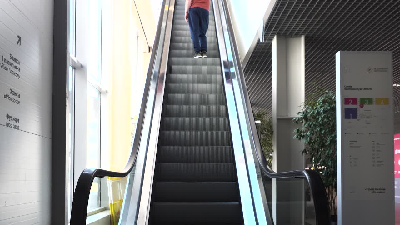 쇼핑몰 에서 에스컬레이터 를 올라가는 사람