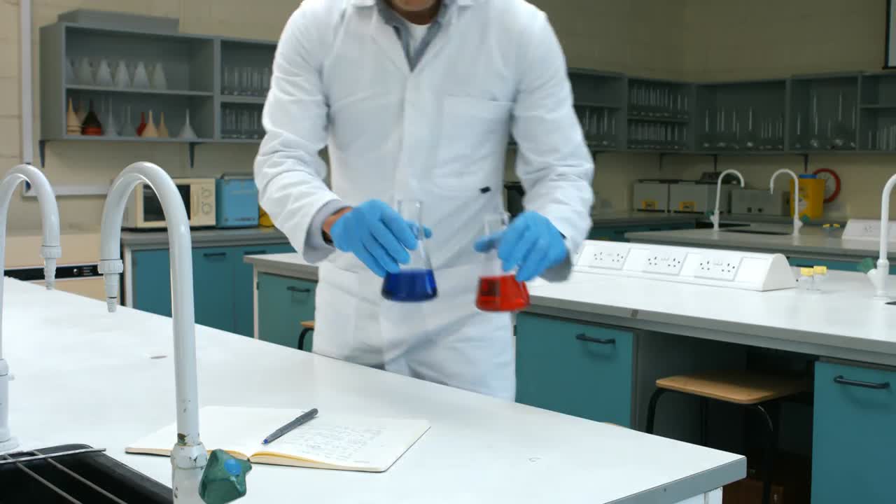 científico con una muestra de químico rojo y azul escribiendo sus notas