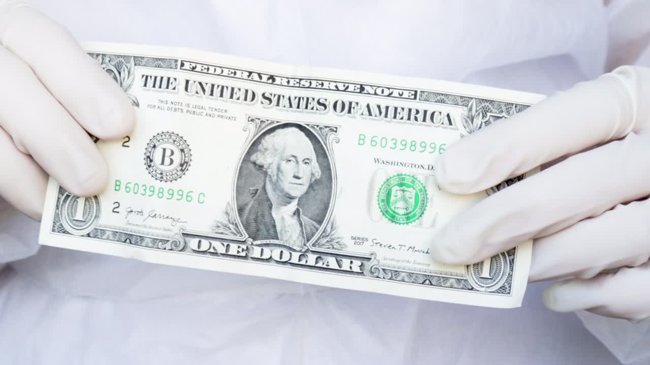 간호사 나 의사 는 양 손 에 1 달러 지폐 를 들고 있다