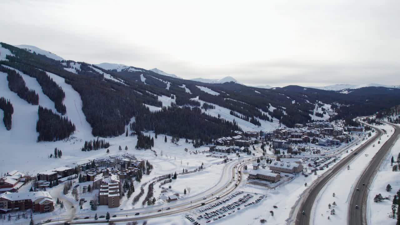 vuelo de drones sobre una estación de esquí con carreteras transitadas al lado de la autopista