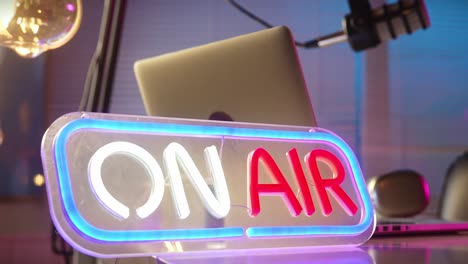 on air neon sign with podcast and broadcast studio equipment