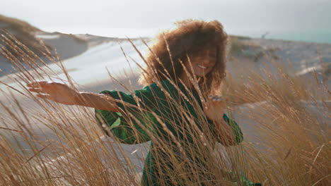 smiling woman sitting dunes at summer day close up. happy girl sitting on sand.