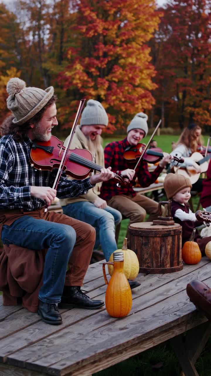 A lively autumn video scene with musicians playing violins outdoors