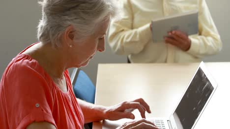 senior man and woman using laptop and digital tablet