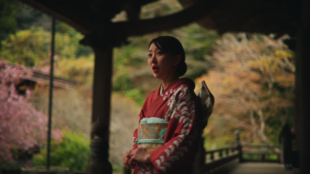 Woman in Kimono at Japanese Garden with Cherry Blossoms