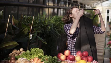 portrait of positive cheerful independent youth millennial girl, feel confident and successful in retail, putting black apron and ready for work in bright indoors greenhouse