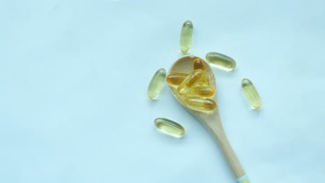 fish oil supplement on a spoon on white background