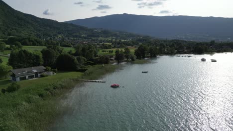 shore aerial shot of lake annecy france sunset, ripples on water