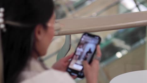 woman scrolling through phone content in a mall