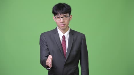 젊은 아시아인 사업가들이 악수를 하고 있다.
