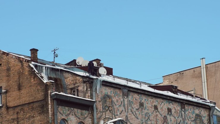 Uomo su un tetto innevato in inverno
