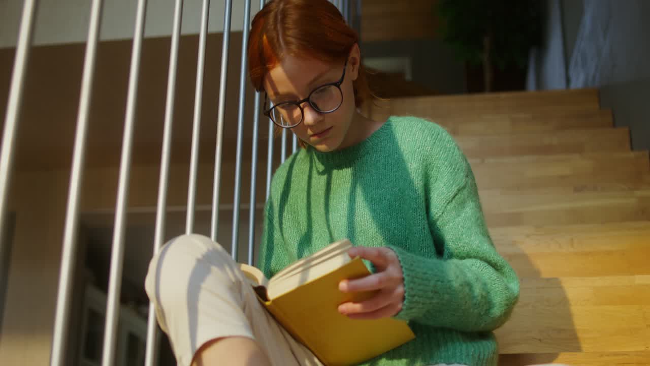 십대 소녀가 계단에서 읽고 있다