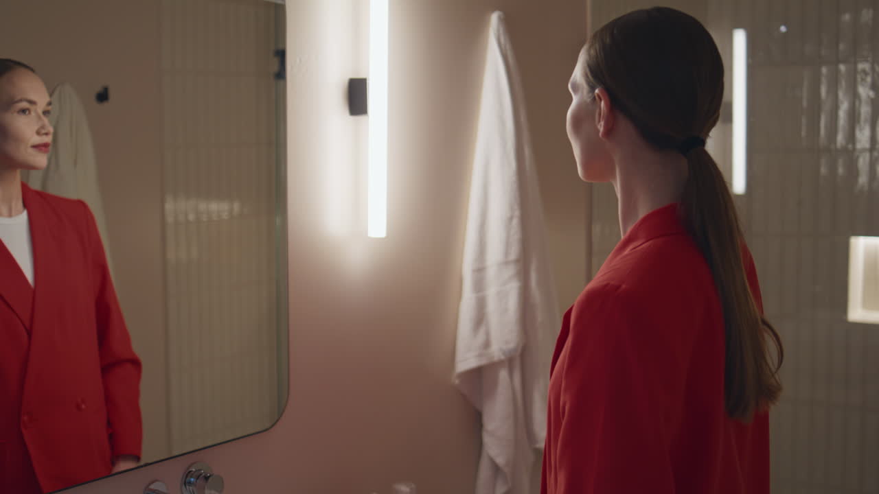 Girl reflection admiring beauty in soft bathroom light. woman adjust