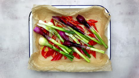 tray of colourful vegetables being drizzled with olive oil