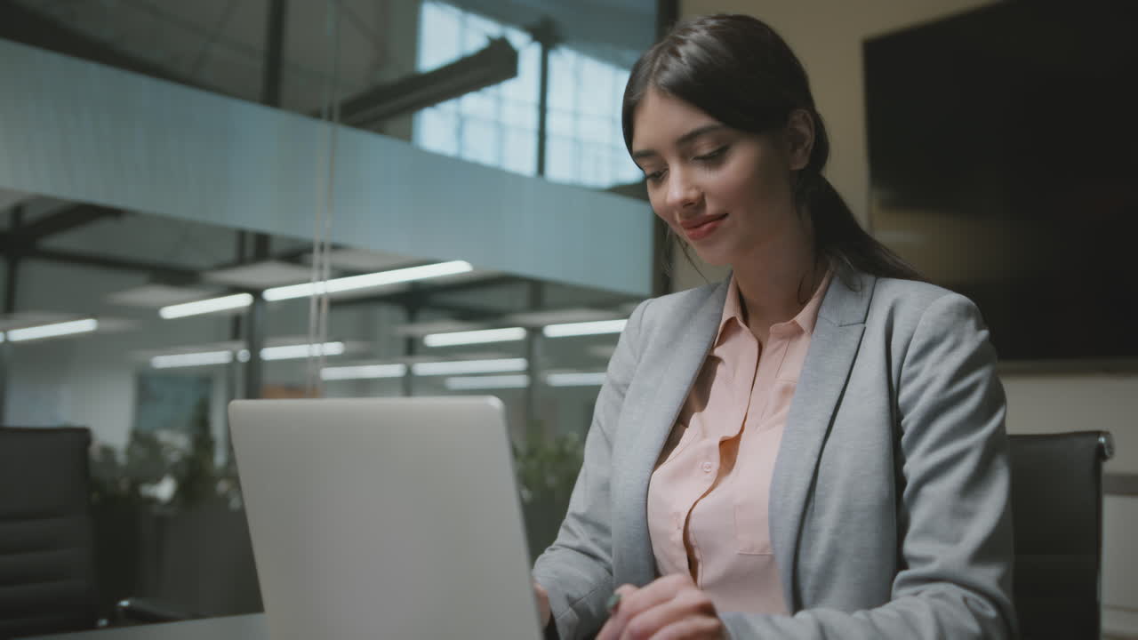 Jovem Empresária Trabalhando em um Laptop em um Escritório