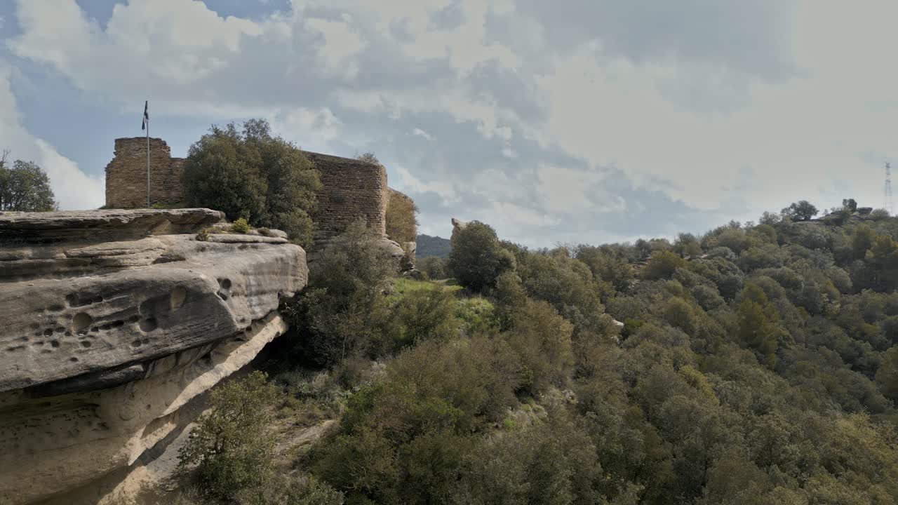 Majestic sandstone formations provide a dramatic backdrop to the eighth century taradell castle, its weathered stone walls standing sentinel over the verdant catalonian landscape