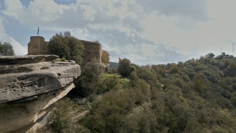 majestic sandstone formations provide a dramatic backdrop to the eighth century taradell castle, its weathered stone walls standing sentinel over the verdant catalonian landscape
