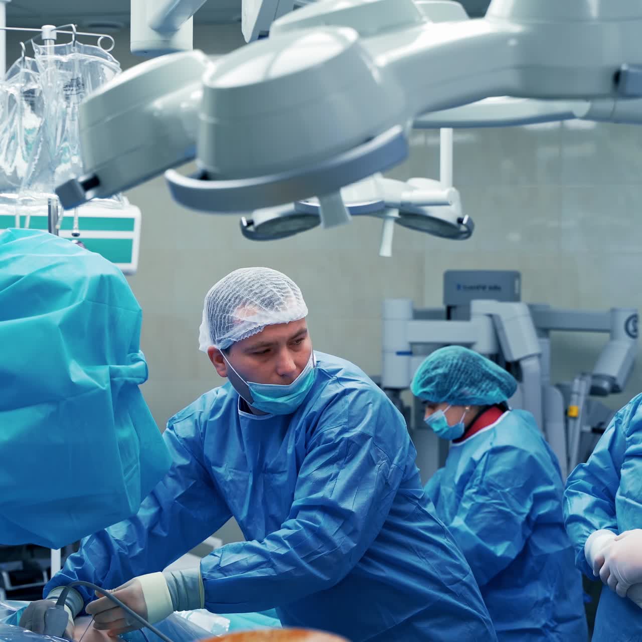 Group of doctors in medical uniform in surgical room. Surgeons perform an operation on modern medical equipment background.