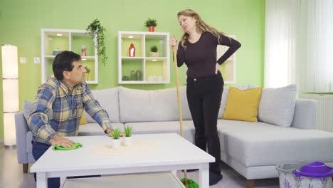 the mature couple, tired of cleaning, sit on the sofa and rest for a while.