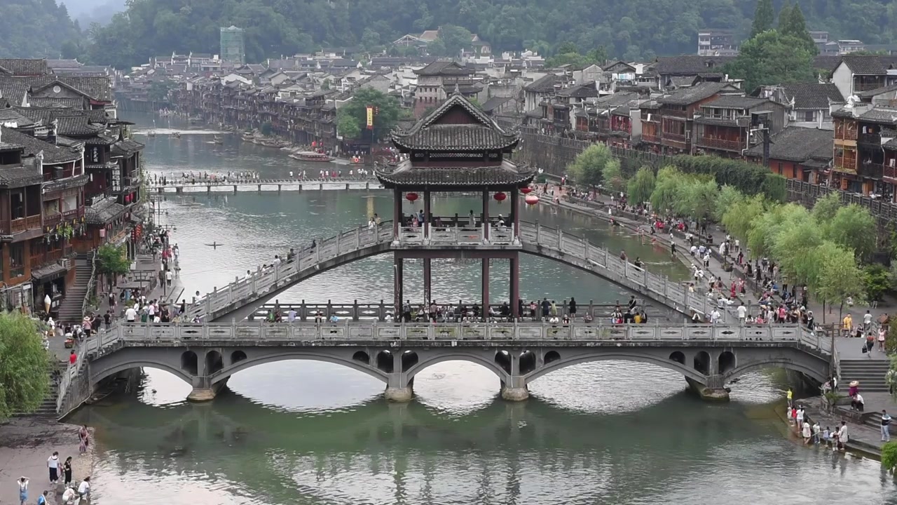 Com vista para a Cidade Antiga de Fenghuang, na Província de Hunan, China, esta vista deslumbrante destaca o encanto histórico da cidade com arquitetura chinesa tradicional, casas sobre palafitas e ruas de paralelepípedos.
