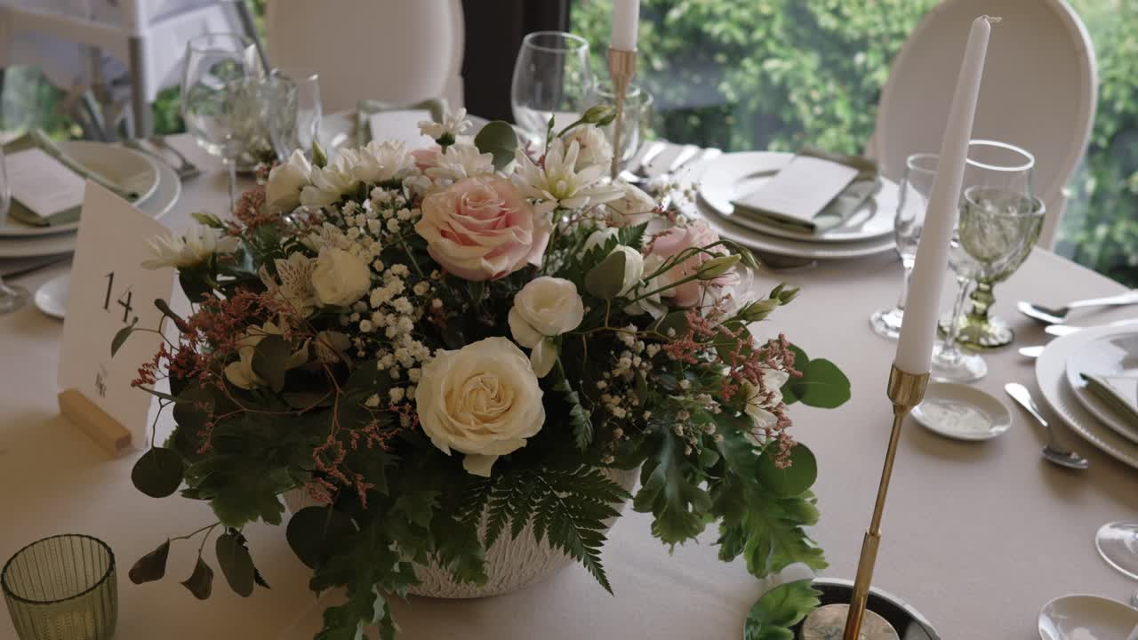 Romantic floral wedding centerpiece on a formal table setting with soft light