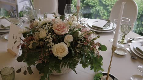 romantic floral wedding centerpiece on a formal table setting with soft light