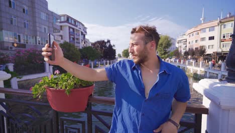 young man talking on video chat in the city.