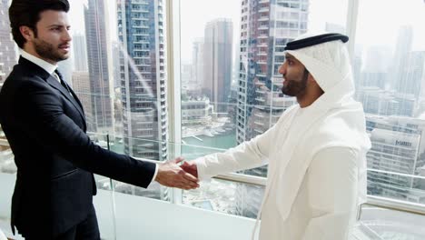 middle eastern and caucasian businessmen meeting downtown building