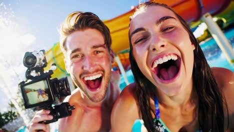 excited couple vlogging at a water park