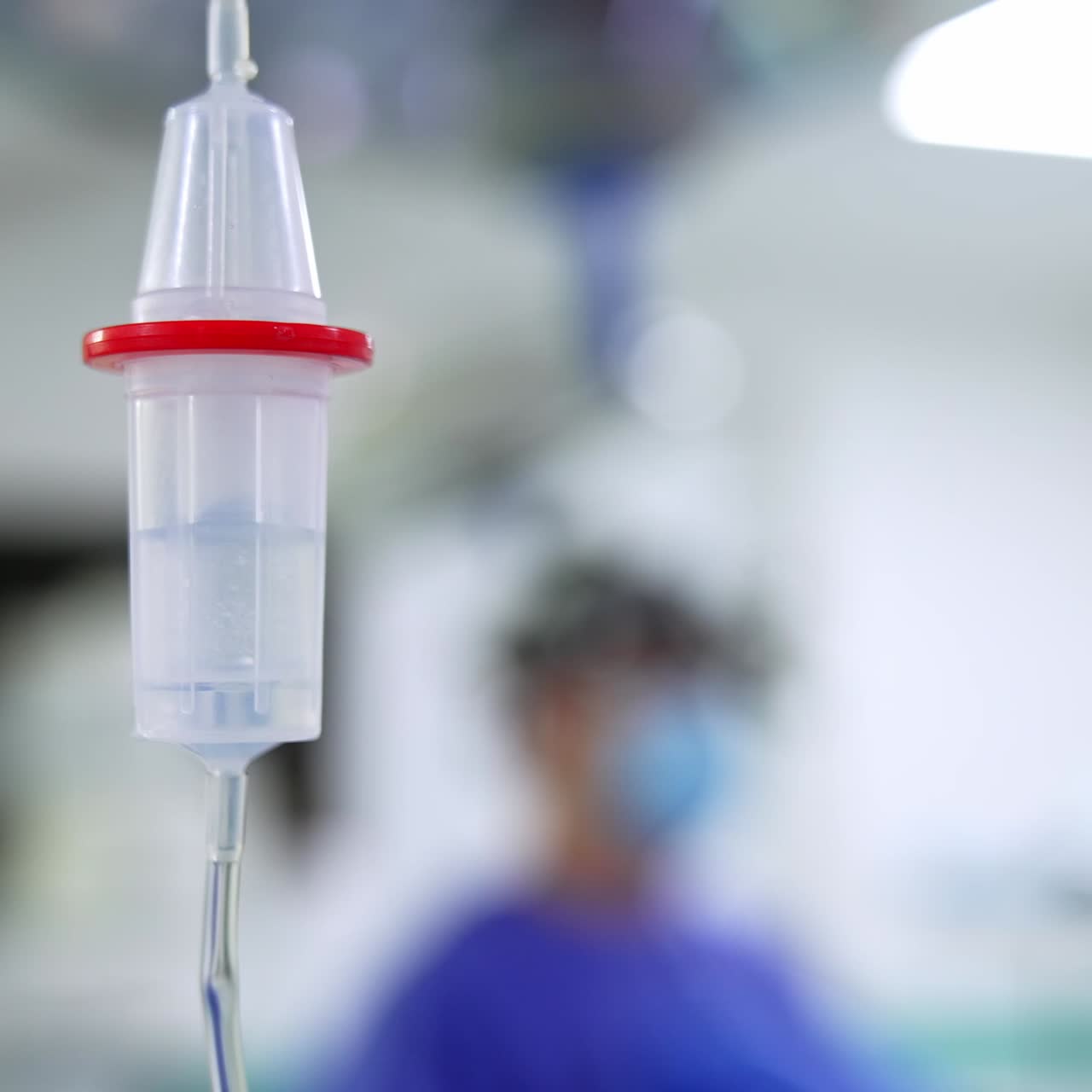 Contagocce con medicine che gocciolano all'interno. Attrezzatura medica per operazioni chirurgiche in sala operatoria. Primo piano. Sfondo sfocato