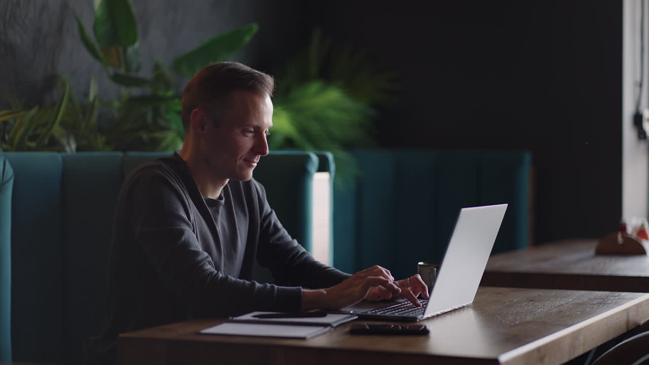 beautiful male developer or student working studying by laptop in cafe. freelance remote work online education self employed