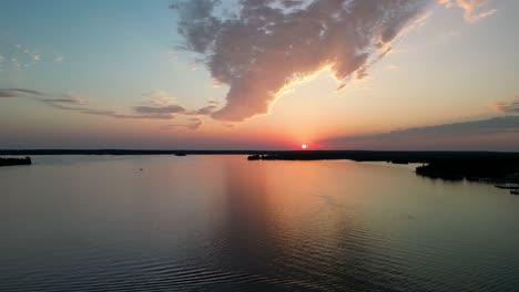 Vista-Aérea-De-La-Puesta-De-Sol-Sobre-Un-Lago-Tranquilo-Con-Reflejo,-Michigan