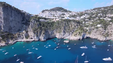 Aerial-drone-dolly-shot-of-boats,-yachts-on-the-coastline-of-Capri,Italy